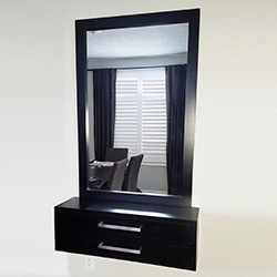 Renovation with black framed mirror and black drawers
