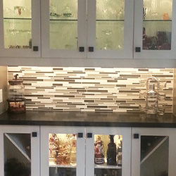 Kitchen renovation project, multicolour tile backsplash with white cabinets and black granite countertop