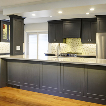 A kitchen renovation with a white countertop and black cabinets